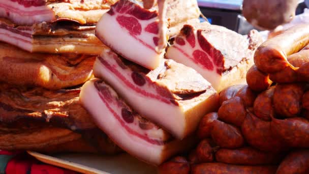 Verschiedene Fleischprodukte Wurst und Speck auf einem Tisch. Streetfood. - Filmmaterial, Video