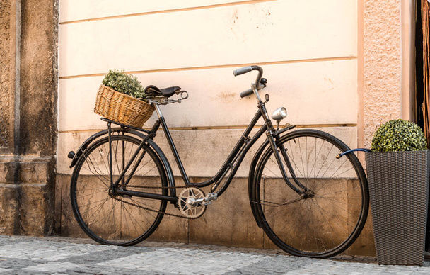 retro bicycle in front of a brick wall in the street with a basket of green flowers - Photo, Image