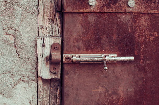 Old shabby metal rusty door with latch unlocked - Foto, afbeelding