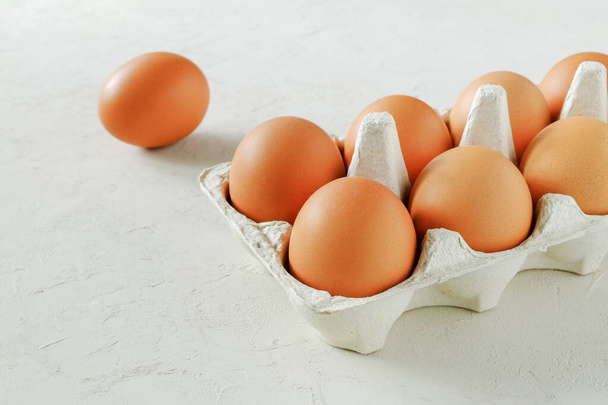 Kananruskeita tuoreita raakoja munia munasäiliössä. Ainekset ruoanlaittoon. Terveellinen syöminen on käsite. Horisontaalinen suuntautuminen, valikoiva kohdentaminen. - Valokuva, kuva