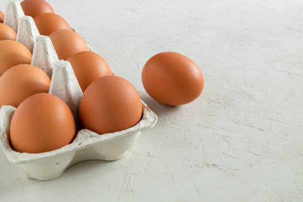 Kip bruin verse rauwe eieren in een ei container. Ingrediënten voor het koken. Gezond eten is een concept. Horizontale oriëntatie, selectieve focus. - Foto, afbeelding
