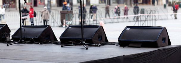 Sistema de monitor de palco, uma fila de monitores de palco, três alto-falantes horizontais na borda do palco, cunhas, foldbacks perto dos microfones vocalistas, ninguém. Conceito de mistura sonora de desempenho ao vivo
 - Foto, Imagem