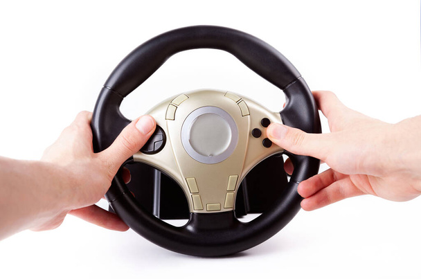 Рулевое колесо гоночной аркады, обе руки держат колесо автомобиля за руль с большим количеством кнопок, изолированных от белого, вид от первого лица, нажатие, кнопки. Человек за рулем автомобиля
 - Фото, изображение