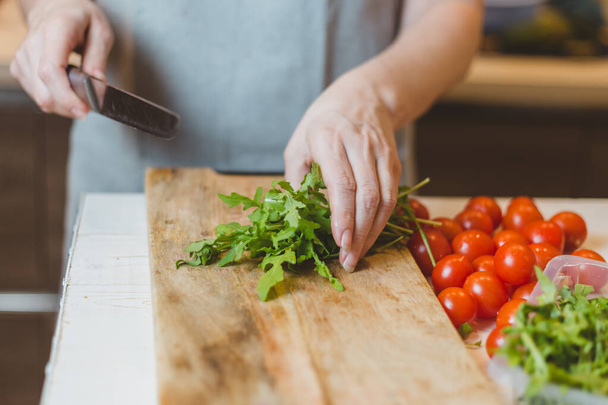 Cook slices vegetables on a cutting board - Foto, Imagen