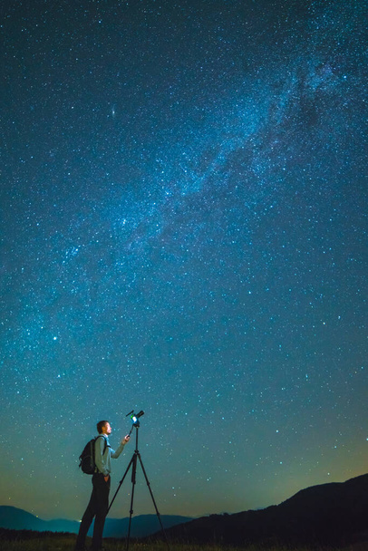 The man with a camera stand on the background of the starry sky. night time - Photo, Image
