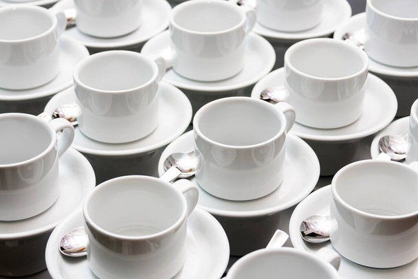 Many empty white tea cups abstract food industry background texture, repetitive pattern Cups stacked with spoons wallpaper White dishes, catering and food service banquet preparations abstract concept - Photo, Image