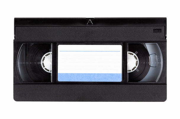 Altes schwarzes Vintage-VHS-Kassettenband vorne mit leerem Papieretikett, Vorderseite, Draufsicht isoliert auf Weiß, ausgeschnittene 80er, 90er Retro-Media-Ästhetik, magnetisches Videokassettenspeicherkonzept Studioaufnahme - Foto, Bild