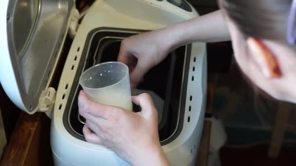 woman puts ingredients in bread maker for baking homemade bread - Footage, Video