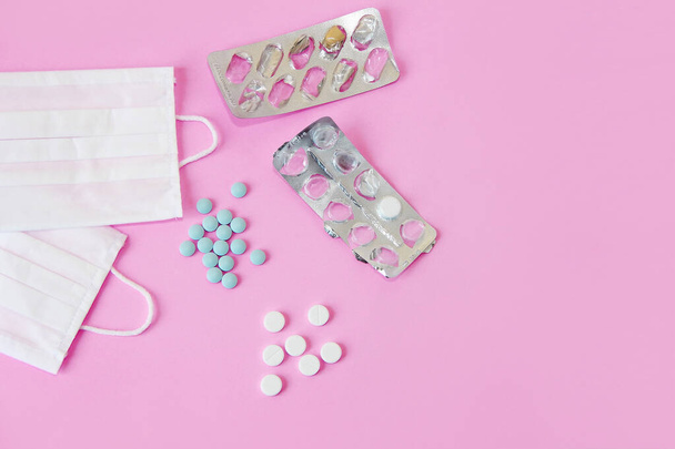medical protective fabric masks and medications tablets on pink background - Fotografie, Obrázek