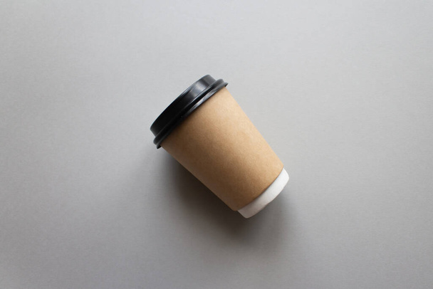 Coffee to go concept. Disposable craft cup with black plastic cover on a trendy grey background. Place for text. Flat lay style. Top view - Valokuva, kuva