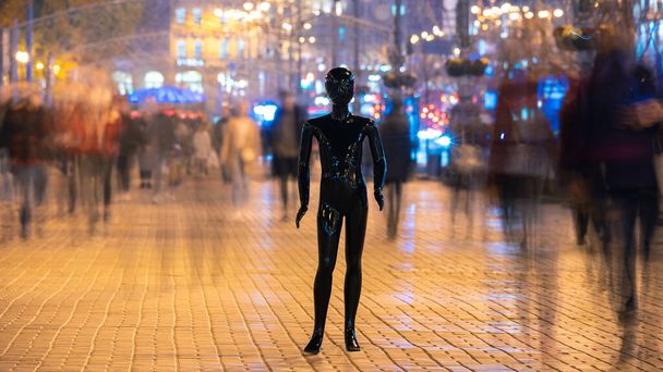 Η μαύρη κούκλα που στέκεται στο δρόμο του πλήθους. βραδινή ώρα - Φωτογραφία, εικόνα
