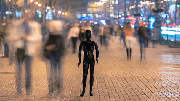 Манекен стоит на улице среди потока людей
 - Фото, изображение