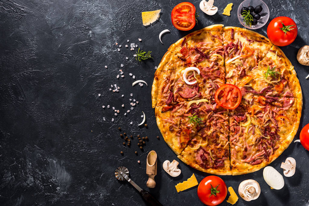 Pachnąca włoska pizza. Składniki żywności i przyprawy do gotowania pysznej włoskiej pizzy, grzybów, pomidorów, sera, cebuli, papryki, soli, bazylii, oliwek na ciemnym, betonowym tle - Zdjęcie, obraz