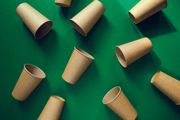 Eco friendly craft paper cups on green background. Recycling concept. Zero waste theme - Photo, Image