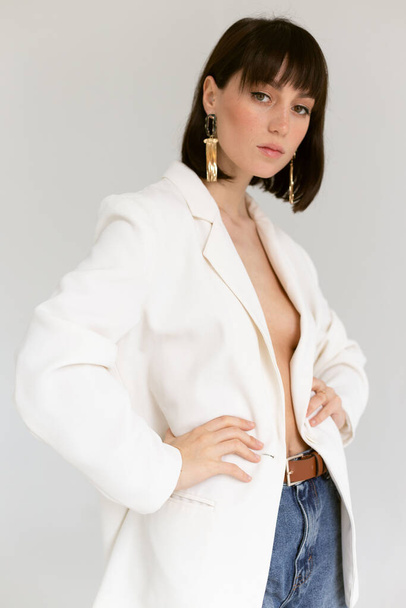 красивая женщина в белом пиджаке позирует в студии
 - Фото, изображение