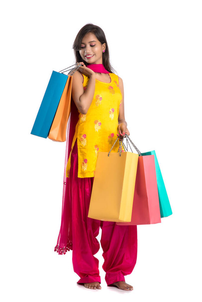 Beautiful Indian young girl holding and posing with shopping bags on a white background - Foto, afbeelding
