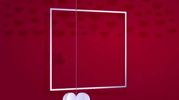 Prvek pružiny pohybující se Objednávka na složení Happy Valentines Day napsáno elegantně uvnitř rámu na červeném pozadí s origami papírové srdce visí kolem s tenkými řetězy - Záběry, video