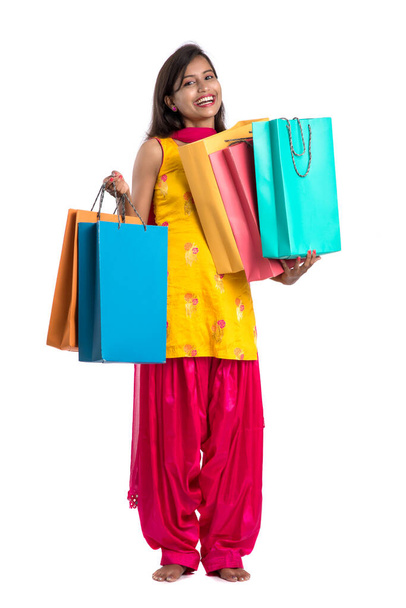 Beautiful Indian young girl holding and posing with shopping bags on a white background - Photo, image