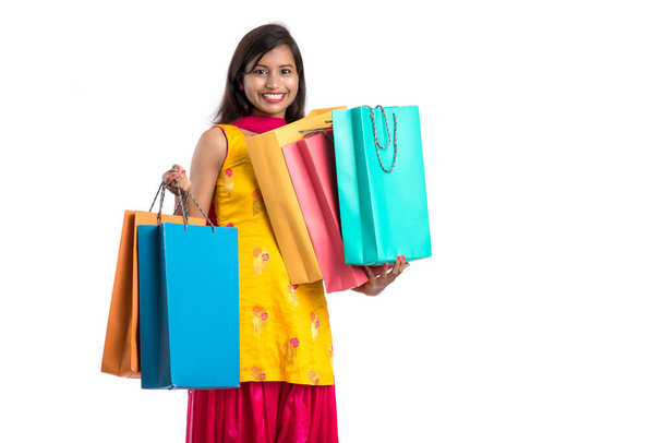 Beautiful Indian young girl holding and posing with shopping bags on a white background - Foto, Imagem