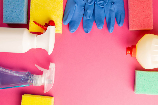 Colorful cleaning set for different surfaces in kitchen, bathroom and other rooms. Empty place for text or logo on pink background. Cleaning service concept. Early spring regular clean up. Top view. - Photo, Image