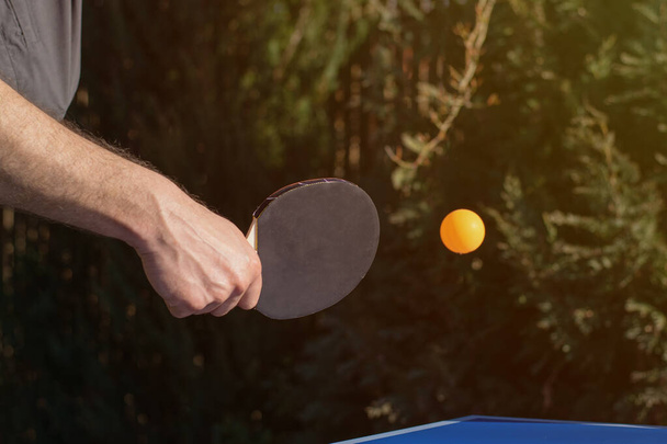 Um homem a jogar ténis de mesa, pingue-pongue no jardim
. - Foto, Imagem