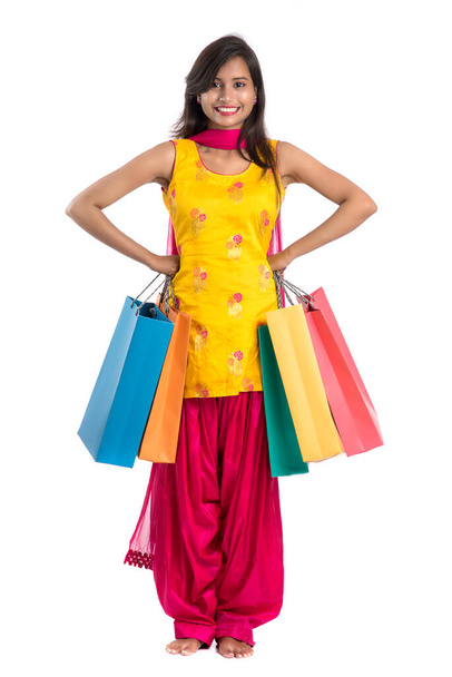 Beautiful Indian young girl holding and posing with shopping bags on a white background - Zdjęcie, obraz