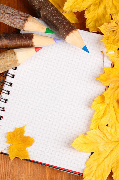 Colorful wooden pencils with autumn leafs on wooden table - Valokuva, kuva