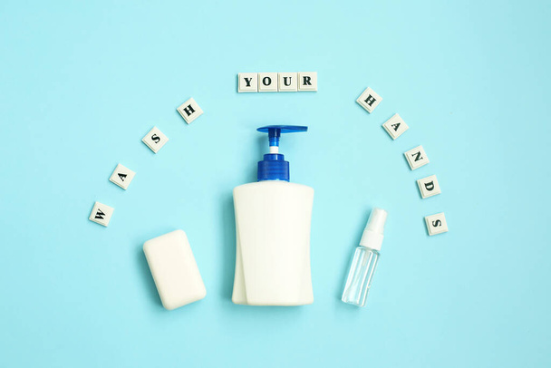Napis WASH Your HANDS z antyseptyki i mydła na niebieskim tle. Motywacyjny cytat. Zapobieganie chorobom. - Zdjęcie, obraz