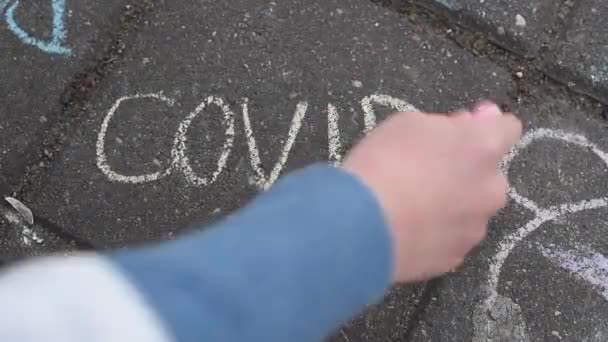 Дитяча рука затіняє напис, прихований на плитці асфальт червоної крейди
  - Кадри, відео
