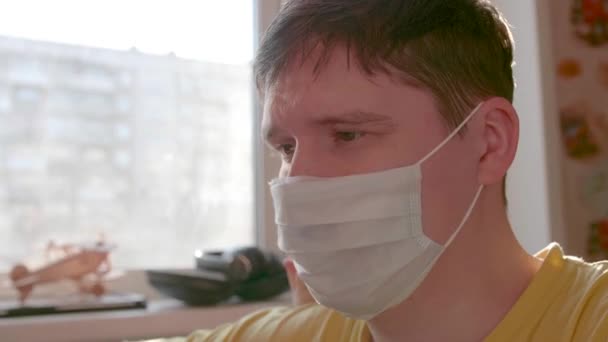 Ο τύπος με την προστατευτική μάσκα μένει στο σπίτι σε αυτοαπομόνωση. Πρόληψη και προστασία της υγείας και της ασφάλειας ζωής. - Πλάνα, βίντεο