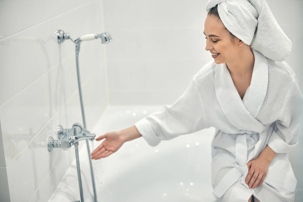 Cheerful lady with white towel on head going to take bath - Foto, Bild