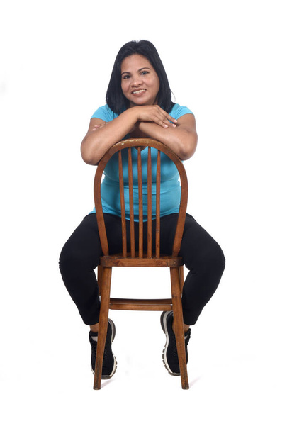 portrait of a woman sitting on a chair in white background, front - Foto, afbeelding