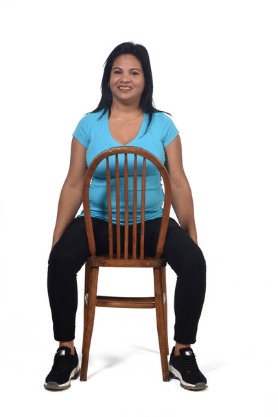 portrait of a woman sitting on a chair and the chair turned on white - Fotoğraf, Görsel