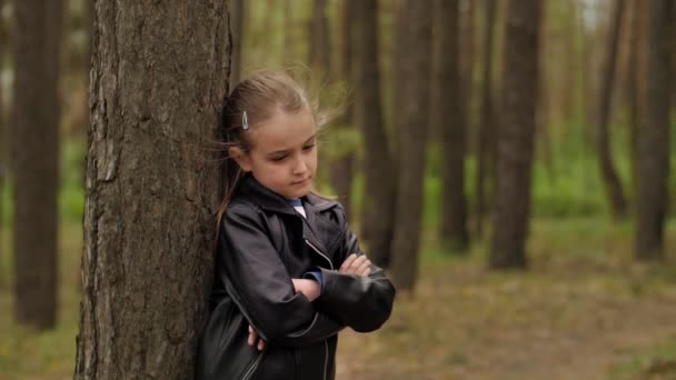 Una triste ragazzina arrabbiata in piedi davanti a un albero nella foresta
 - Filmati, video