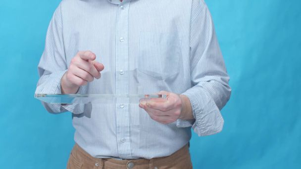 Un hombre sostiene su dedo sobre una tableta transparente
 - Foto, imagen
