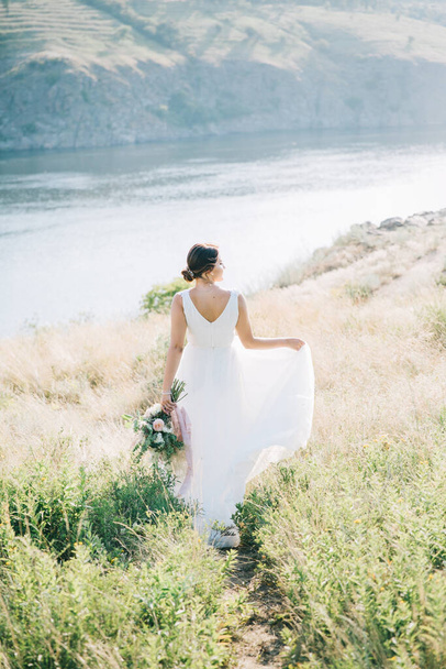 Наречена в розкішному білому весільному вбранні на заході сонця. - Фото, зображення