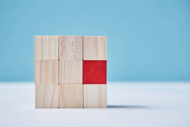 Uniqueness, originality mockup. Personal identity. Not like everyone. Square of uncolored wooden cubes, one red block - Foto, immagini