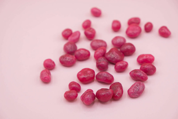  Różowe cukierki są rozrzucone na różowej powierzchni. Świeże rodzynki. Słodycze Ukrainy. - Zdjęcie, obraz