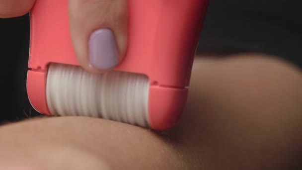 Young woman makes hair removal with an electric epilator. Close-up - Video