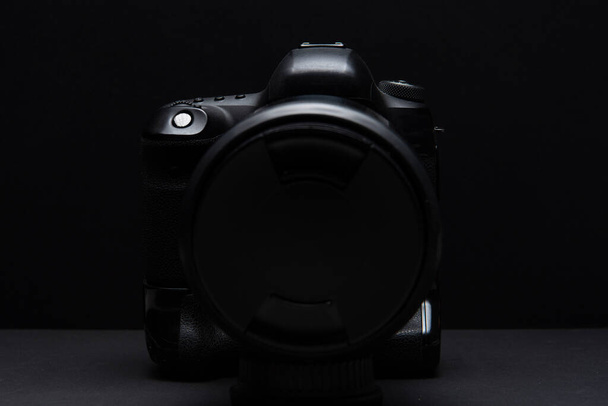 Low-key reflex camera silhouet met overhead verlichting - Foto, afbeelding