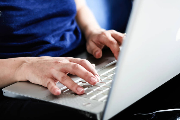 Młoda biała kobieta pisząca na klawiaturze laptopa. Pracuję w domu. Koncepcja inteligentnej pracy - Zdjęcie, obraz