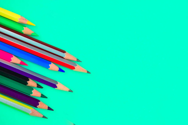 Banda różnych kolorów drewna ołówek kredki umieszczone na szczycie jasnoniebieskiego tła papieru - Zdjęcie, obraz