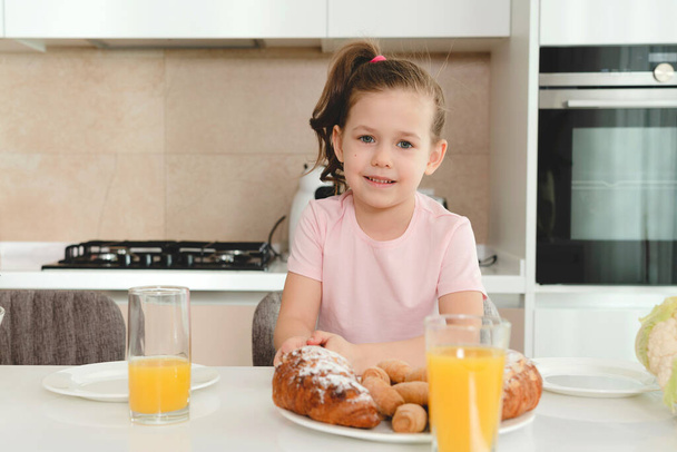 Csinos lány eszik reggelit a konyhában egyedül - Fotó, kép