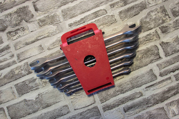 Набор ключей под гайками на фоне кирпичной стены
. - Фото, изображение