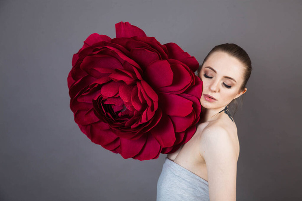 beautiful young model with tattoos and soft skin after Spa treatments and cosmetics with a red rose - Foto, afbeelding