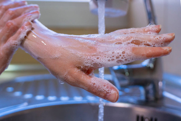 Washing hands and arms properly. Hygiene concept. Rubbing with soap and water. - Photo, Image