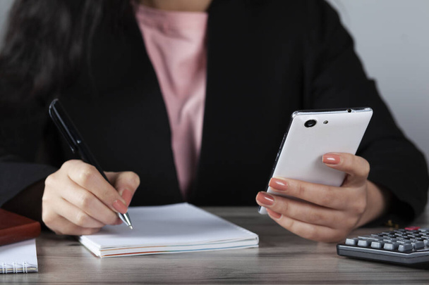 woman hand notepad and smart phone on table - Foto, imagen