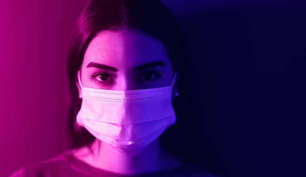 Young woman wearing medical mask against corona virus - Fear girl quarantine for preventing pandemic spread of coronavirus - Mental health impact for covid19 and anxiety people concept - Photo, image