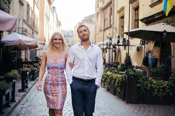 walking down the street together. Happy young man and smiling woman walking through the streets of Old Town, - Foto, imagen