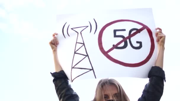 Junge studentische Aktivisten in einer Maske protestieren gegen den Aufbau eines Telekommunikationsnetzes mit 5G-Technologie. Streik während Quarantäne-Covid-19 - Filmmaterial, Video